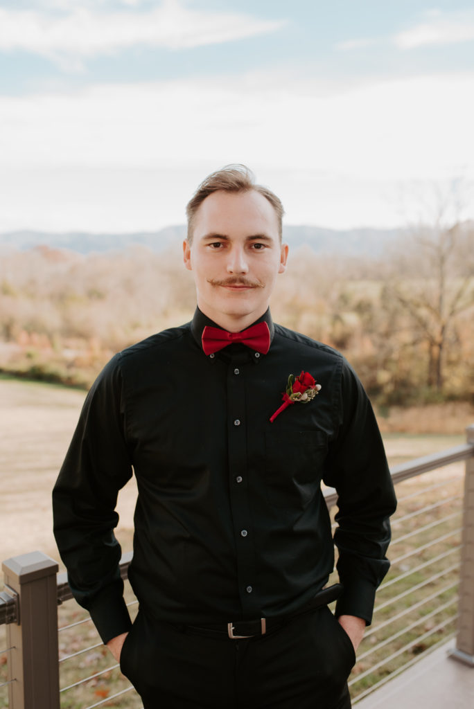 black suit with red bow-tie groom, greenwood oaks farm and venue 