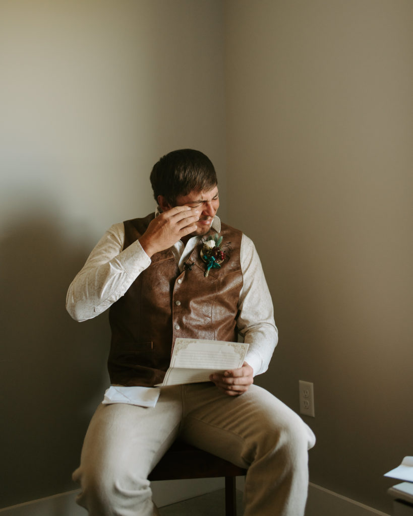 groom reading a letter from the bride before the ceremony on their intimate, Virginia wedding day