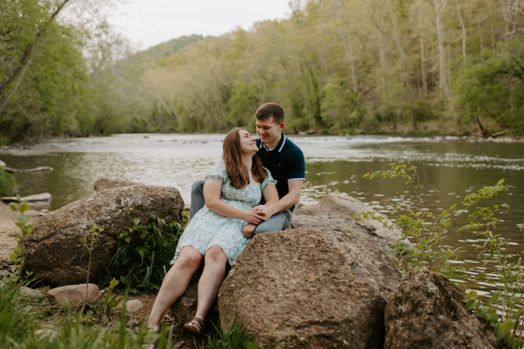 couple sitting on the rocks during the summer in Explore Park