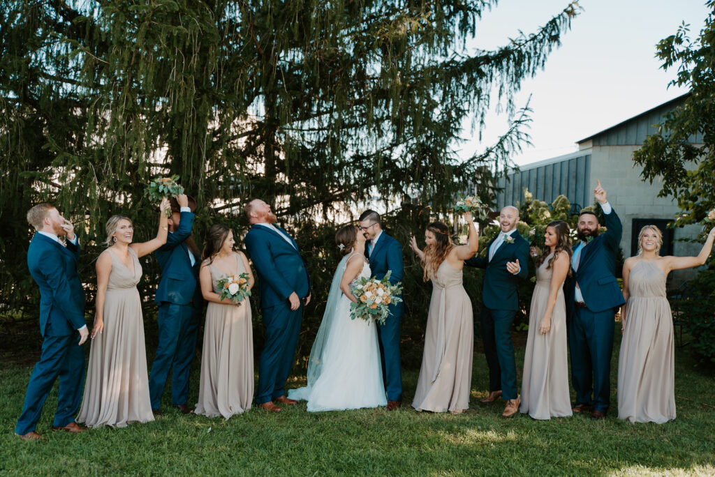 wedding party photo inspiration, cheering while bride and groom kiss photo