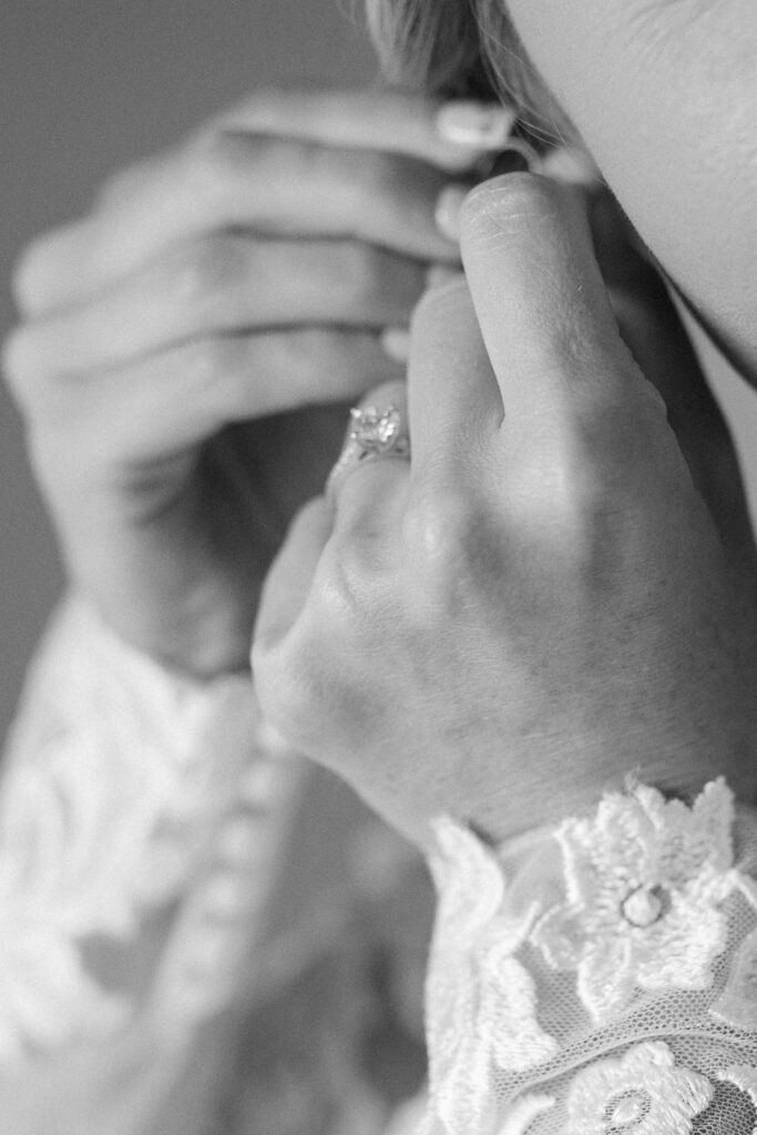 close up wedding ring shot with lacey bridal gown sleeves
