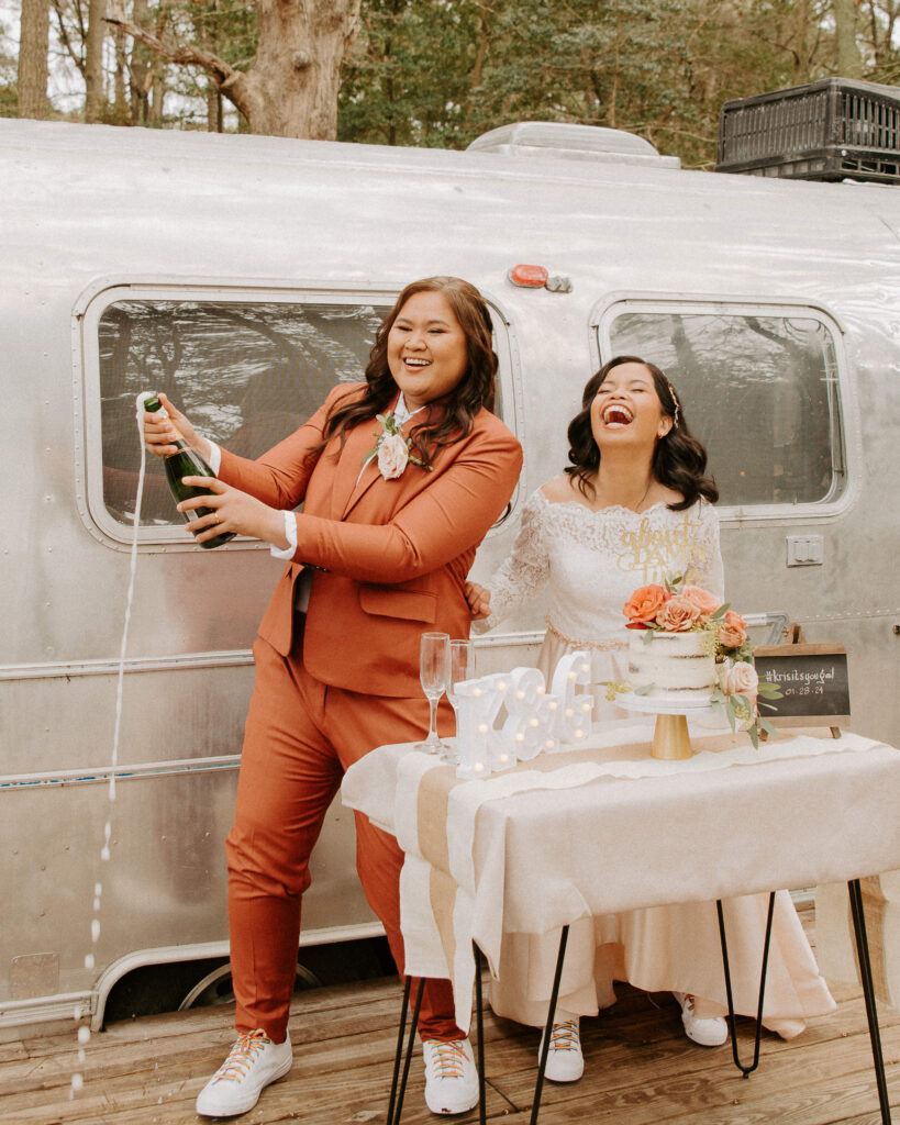 happy married couple popping champagne after their elopement
