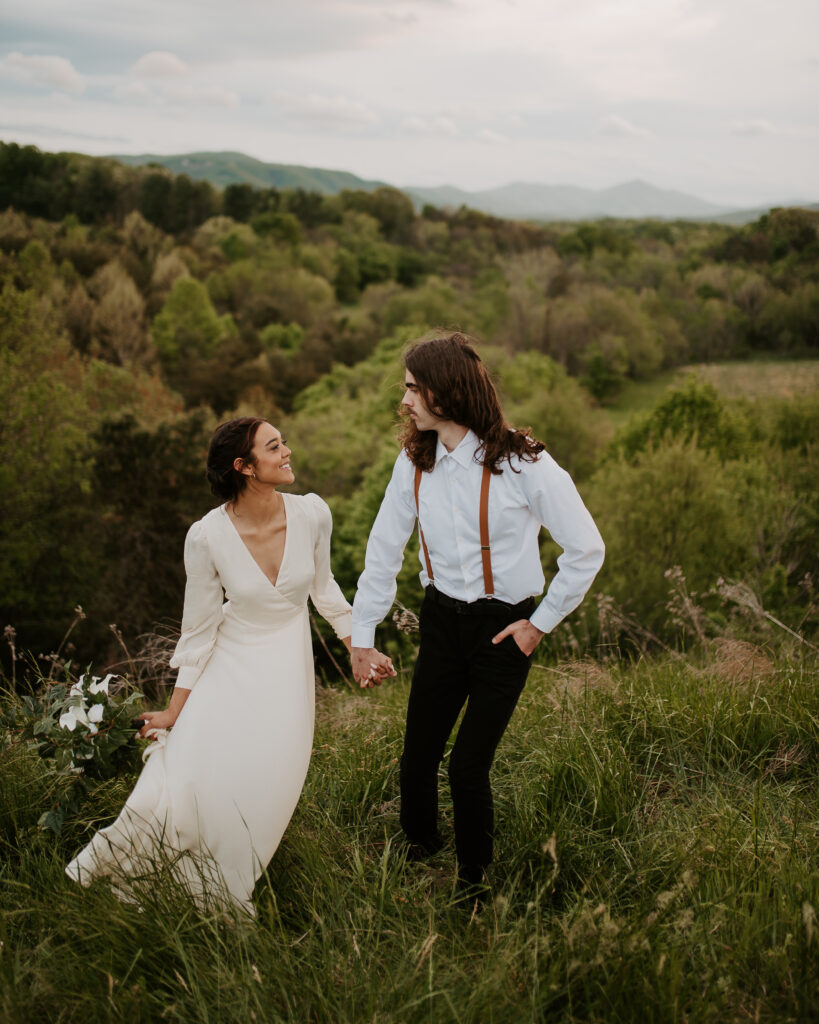 bride wearing a boho off-white dress with the groom wearing suspenders on the blue ridge parkway