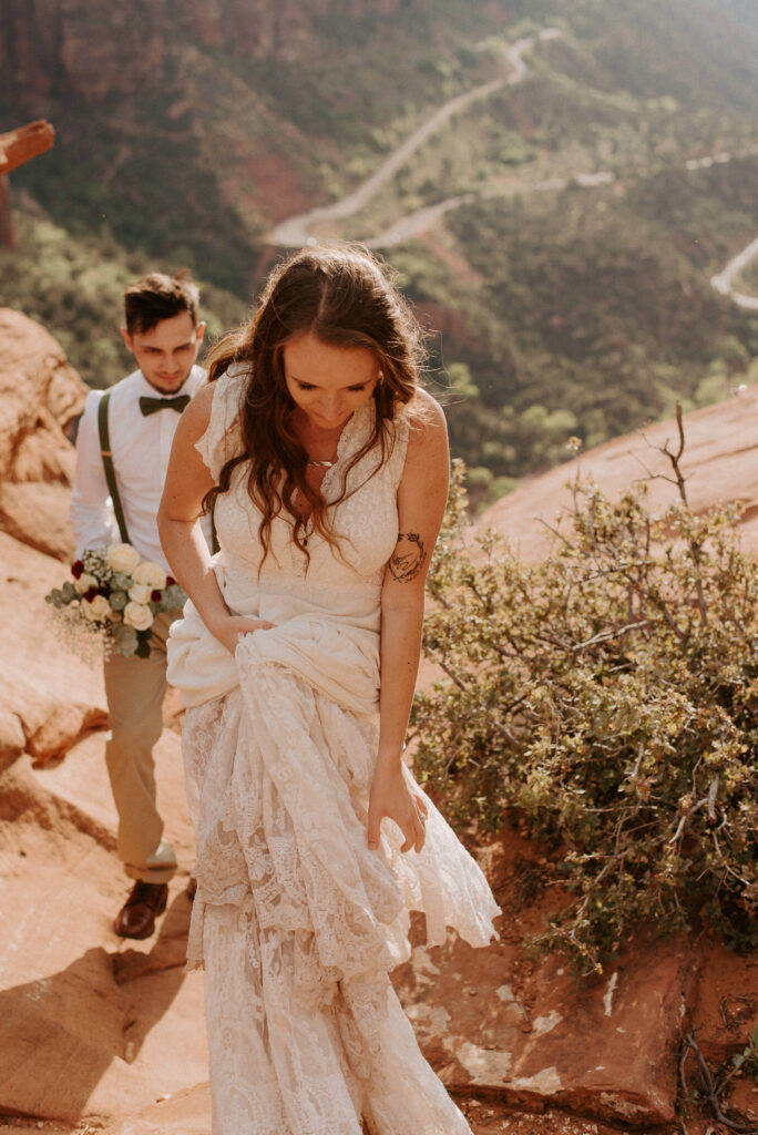 bride and groom walking around Zion Overlook after their Utah elopement