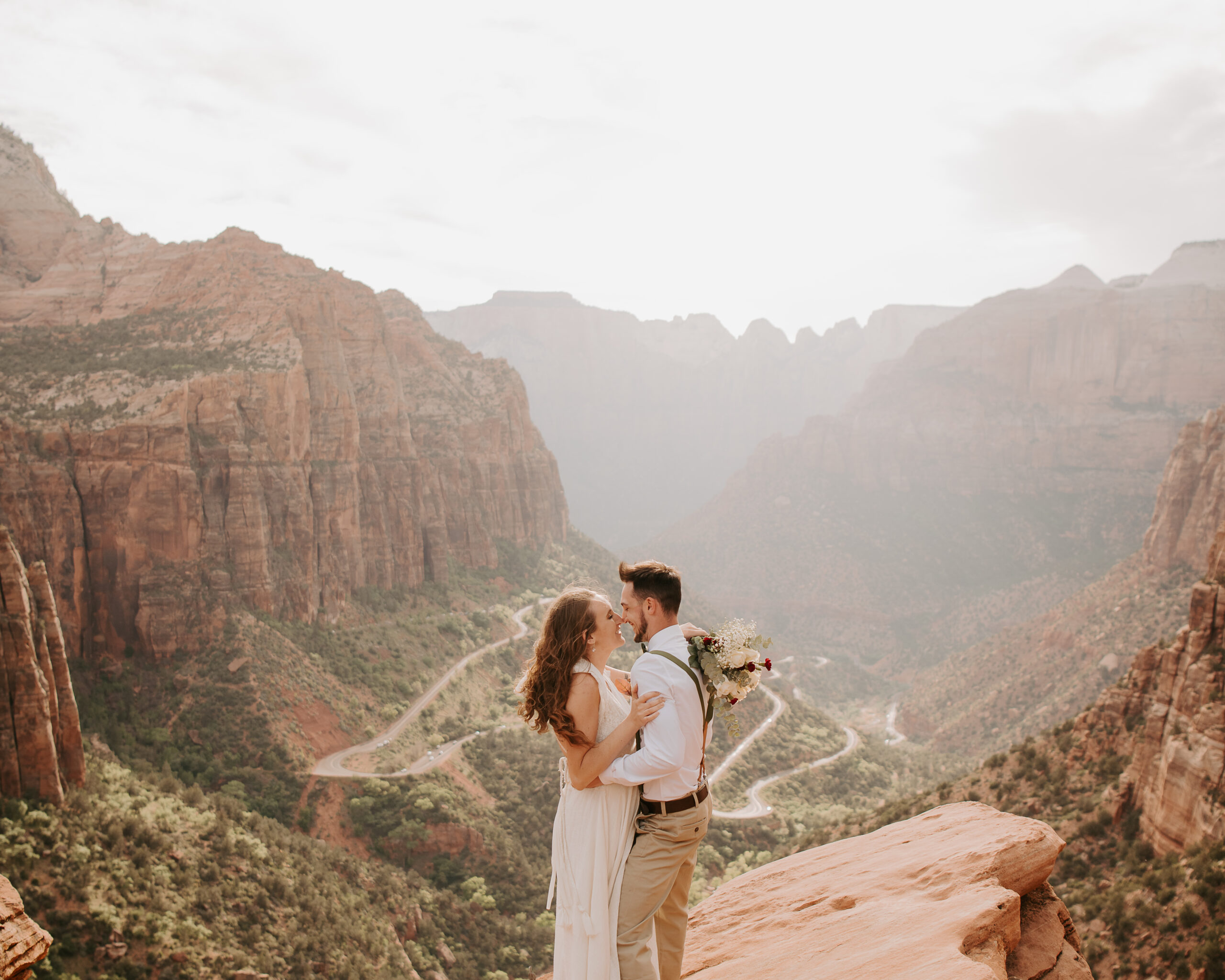 bride and groom kissing overlooking the red rock formations at Zion National Park