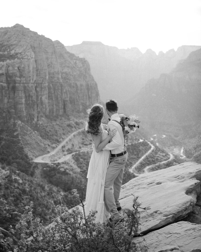 bride and groom at the top of Zion Overlook enjoying the sunset view