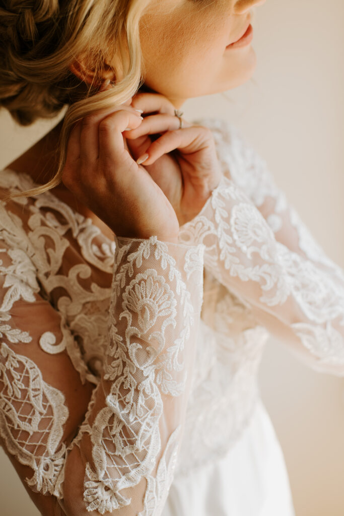 bride putting her earrings on in the bridal suite at Malden Hill Venue