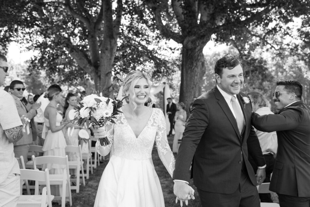 bride and groom walking down the aisle overwhelmed with joy after getting married