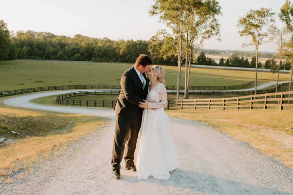 bride and groom kiss with the fields behind them at Malden Hill Venue