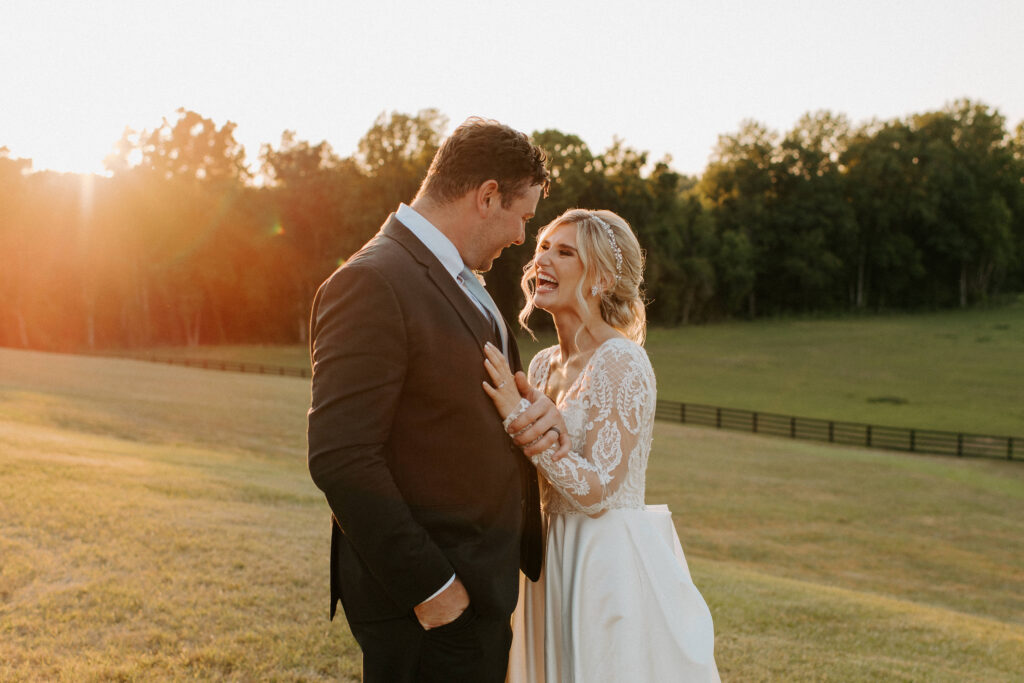 bride laughing with the groom as the sunsets behind them