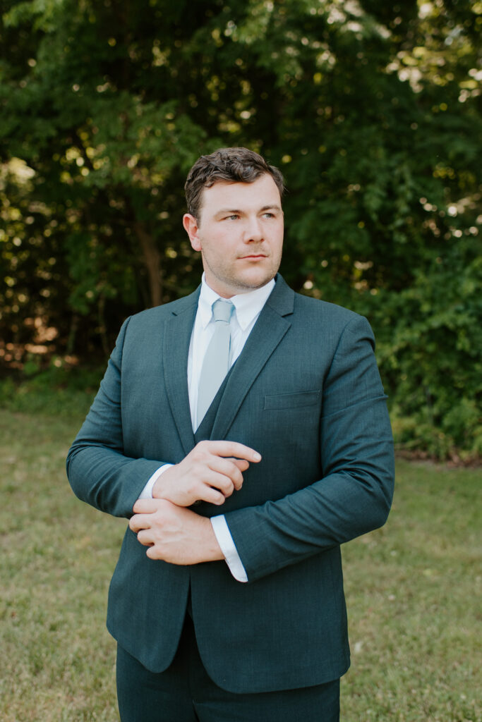 groom wearing a navy suit with a light blue tie