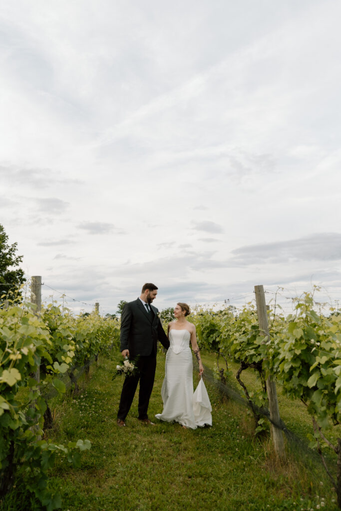 couple walking through vineyard after their wedding in Richmond